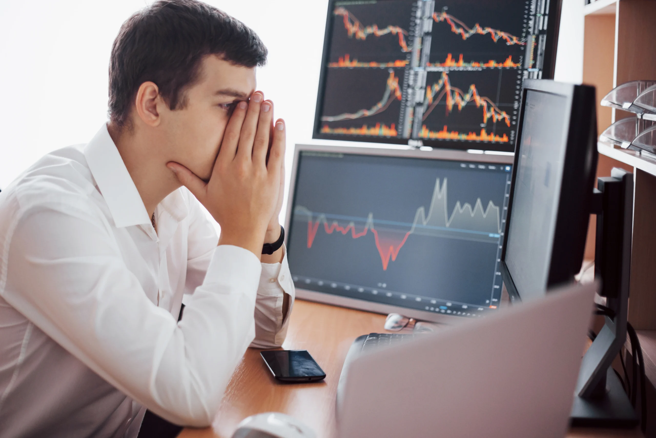 Forex trader analyzing risk management charts and stop loss levels on multiple trading monitors