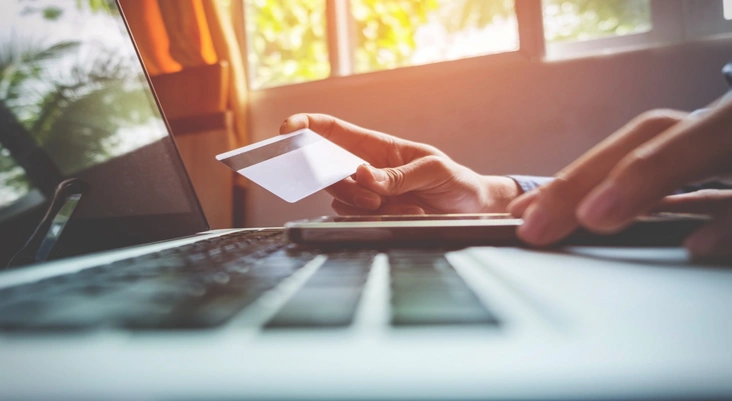 Man Holding Credit Card In Hand Entering Security Code