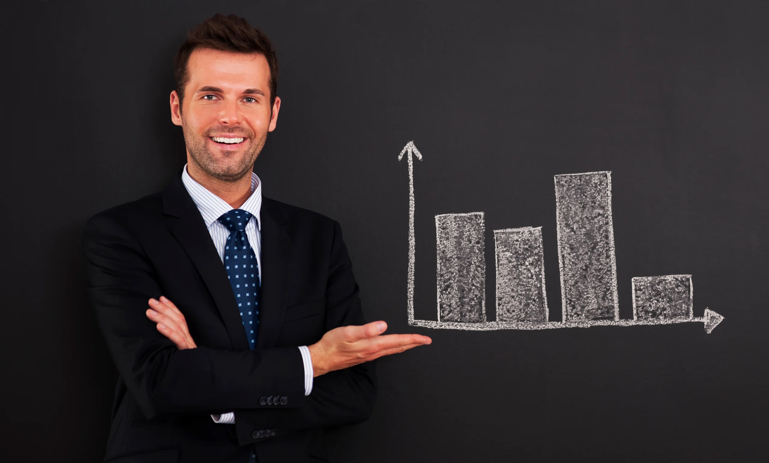 Professional businessman pointing at upward trending charts representing benefits of automated futures trading with speed and efficiency icons displayed